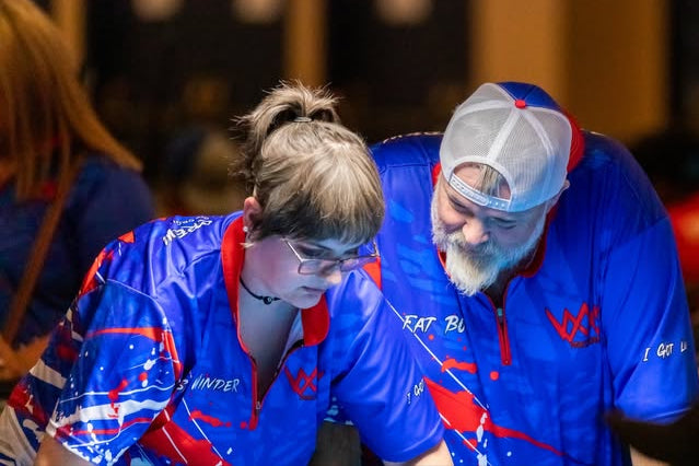 Two people in blue and red Precision Custom jerseys with a blurred background